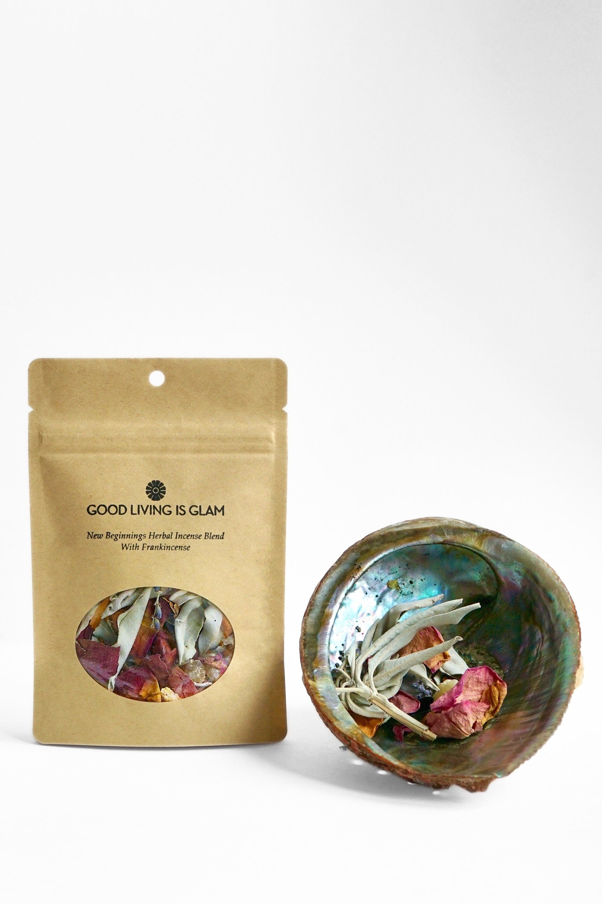 New Beginnings Herbal Incense Blend with frankincense, rose, lavender, and bamboo charcoal in kraft packaging beside abalone shell bowl with herbs