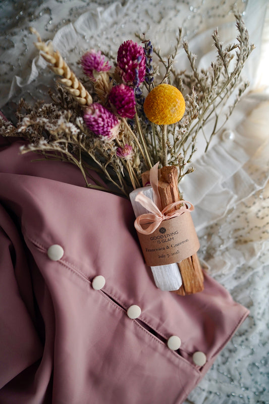 New Beginnings Palo Santo Bouquet with Selenite Crystal and dried seasonal blooms on pink fabric background