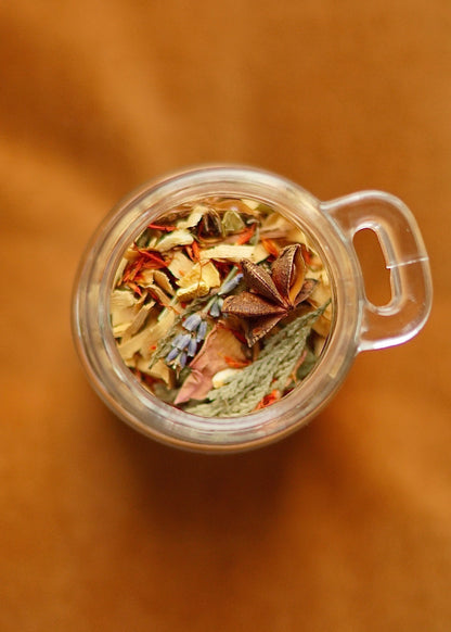 Top view of EverKindle Kindle & Simmer Autumn Incense blend in glass cup with star anise and dried herbs
